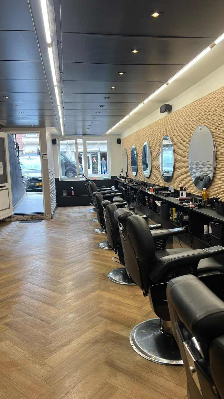 Kapsalon na de schoonmaak door TipTop Cleaning: schone vloer, opgeruimde werkplekken en spiegels